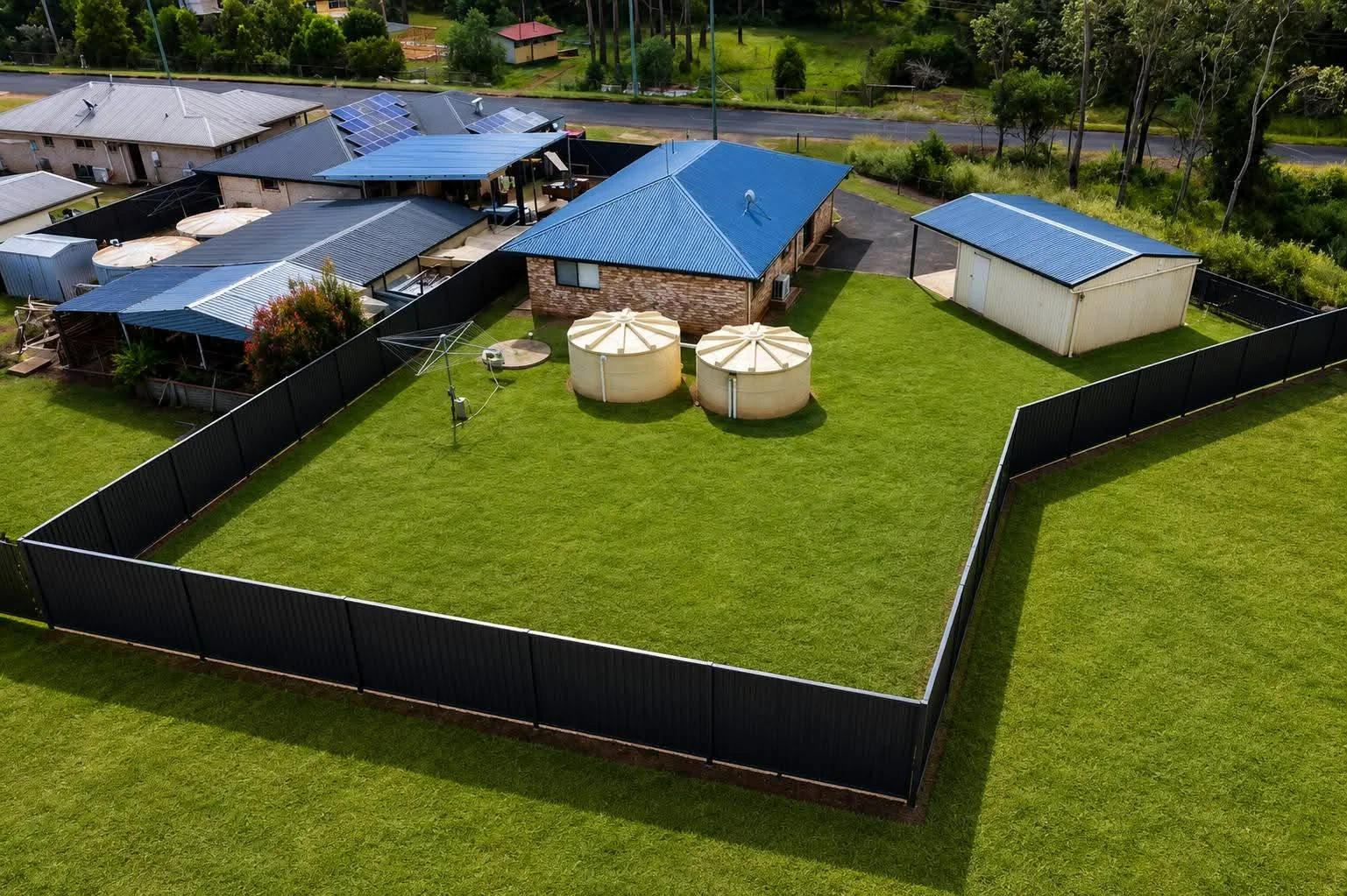 Completed dark COLORBOND boundary fencing photographed from above