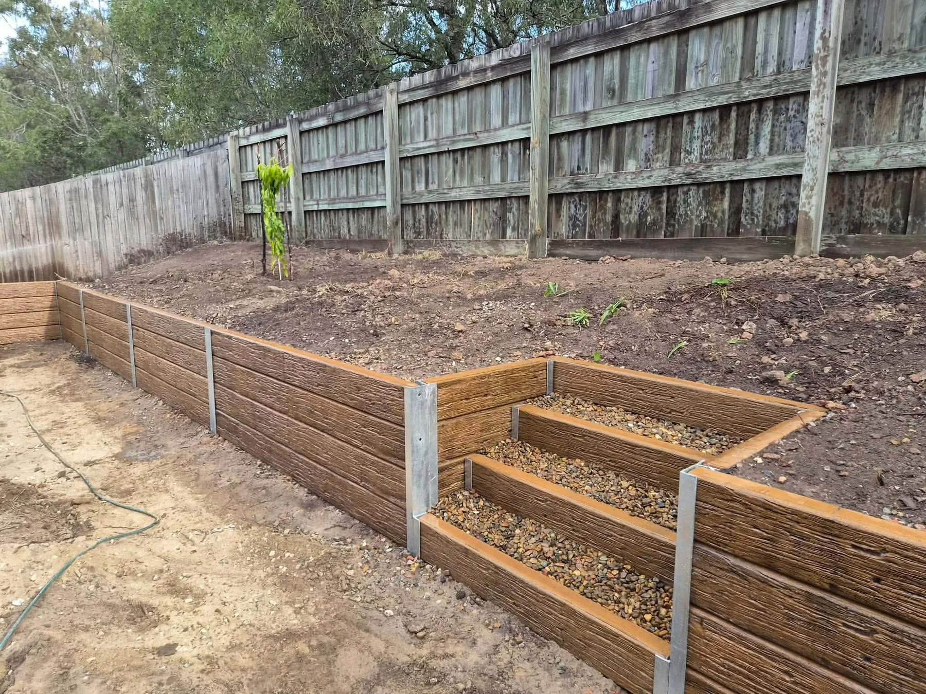 Completed sleeper retaining wall with integrated garden steps